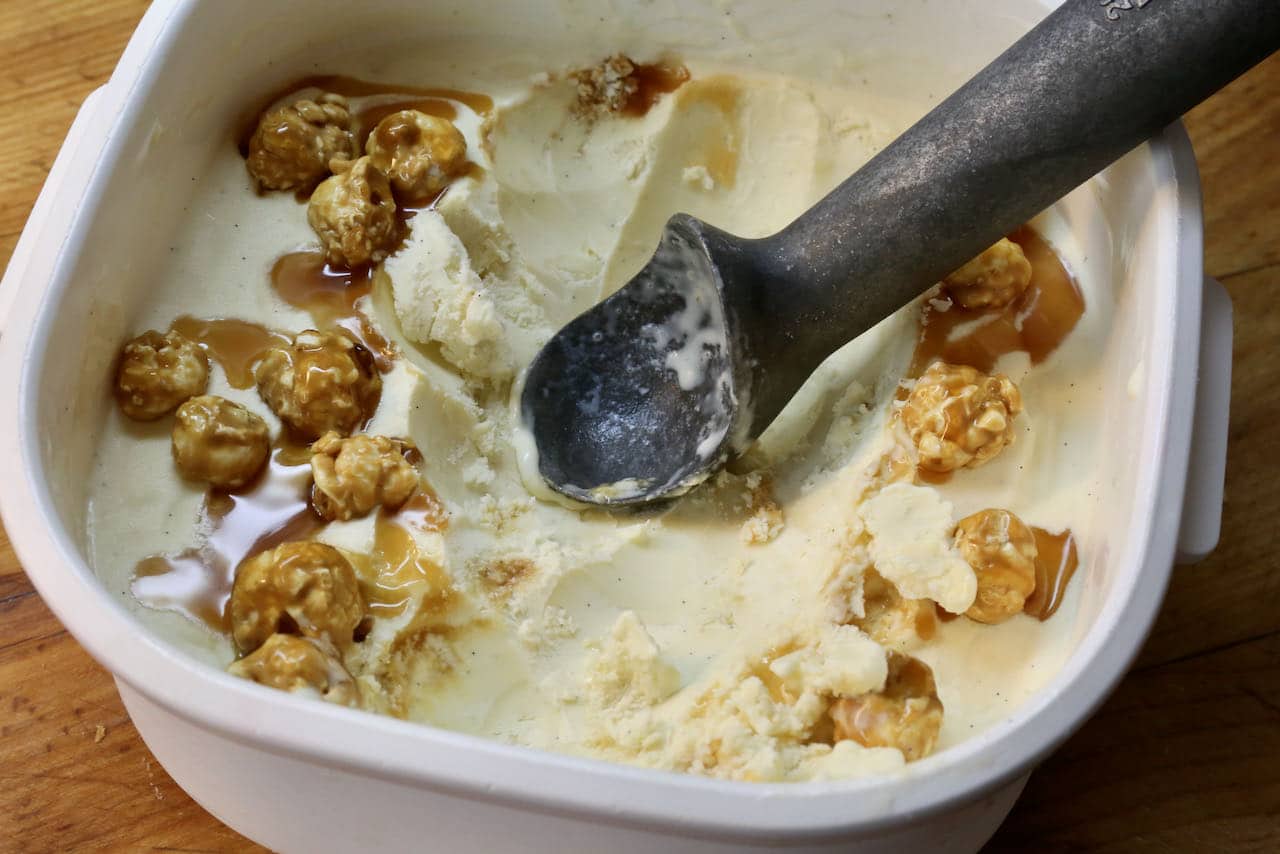 Use an ice cream scoop to serve popcorn ice cream. Make sure to get some caramel corn and caramel sauce in each scoop!