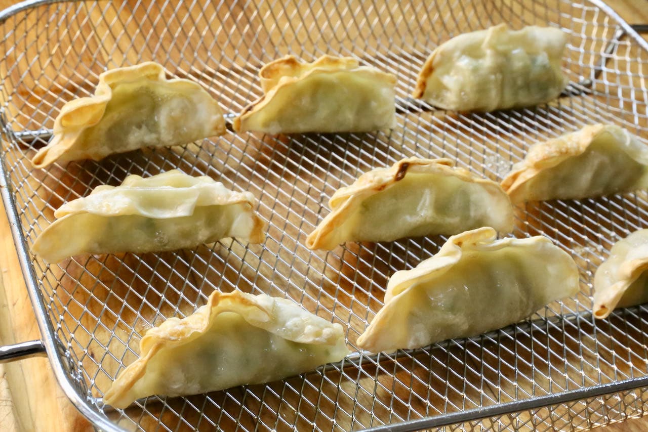 Place frozen dumplings, potstickers or gyoza in a single layer of an air fryer basket after tossing in sesame oil.
