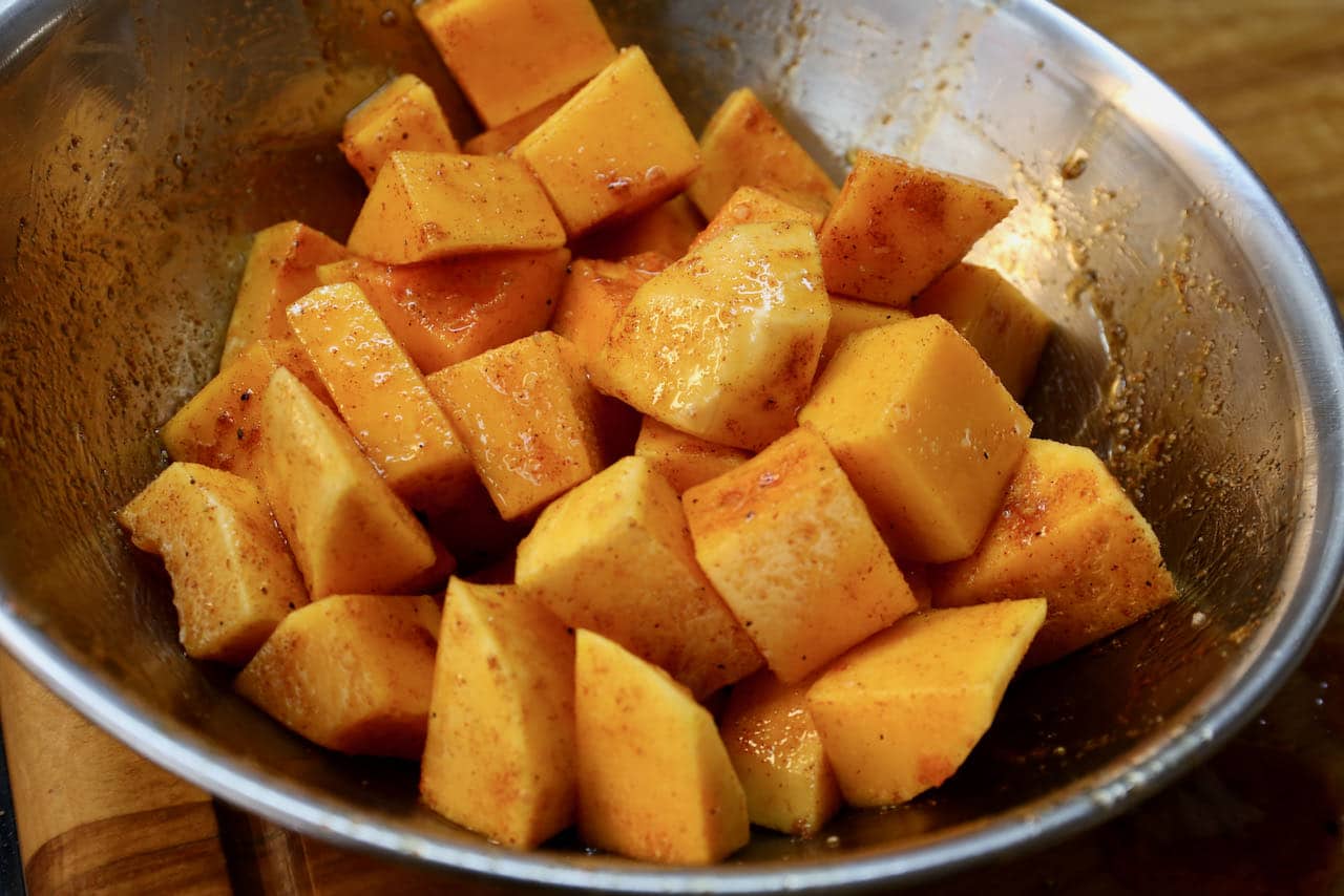 Toss chunks of squash in oil, maple syrup and spice mixture. 