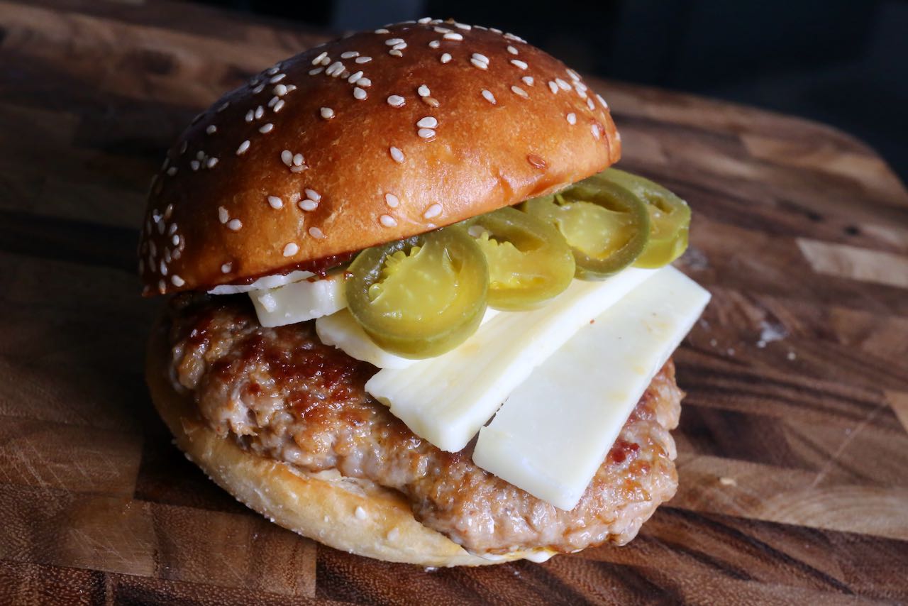 This spicy pork burger recipe gets its heat from Italian sausages and pickled peppers. 