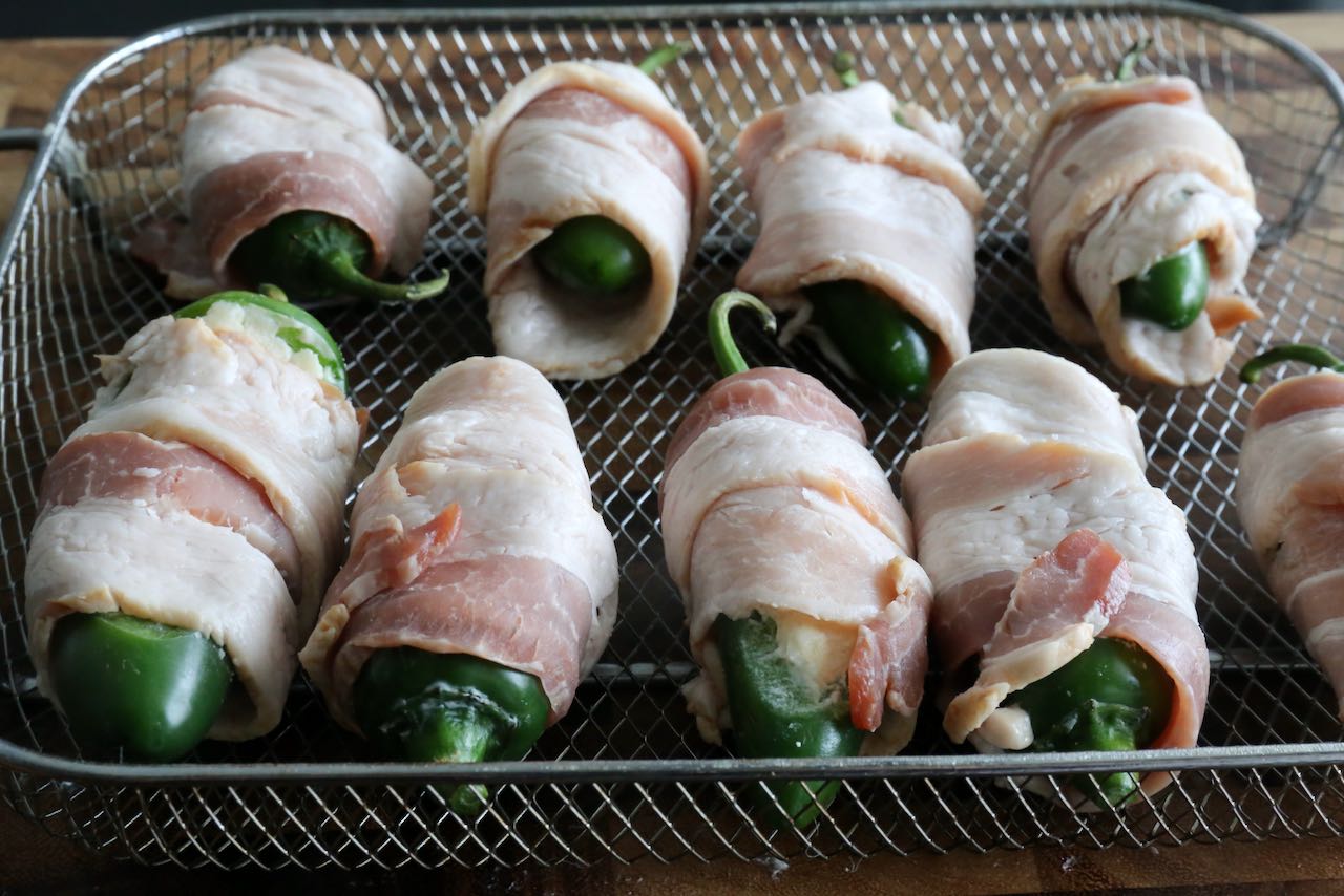 Bacon Wrapped Jalapeno Poppers in Air Fryer Basket.