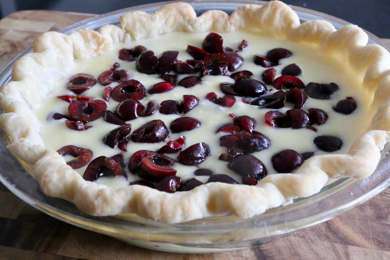 Old Fashioned Cherry Custard Pie ready to bake in the oven.