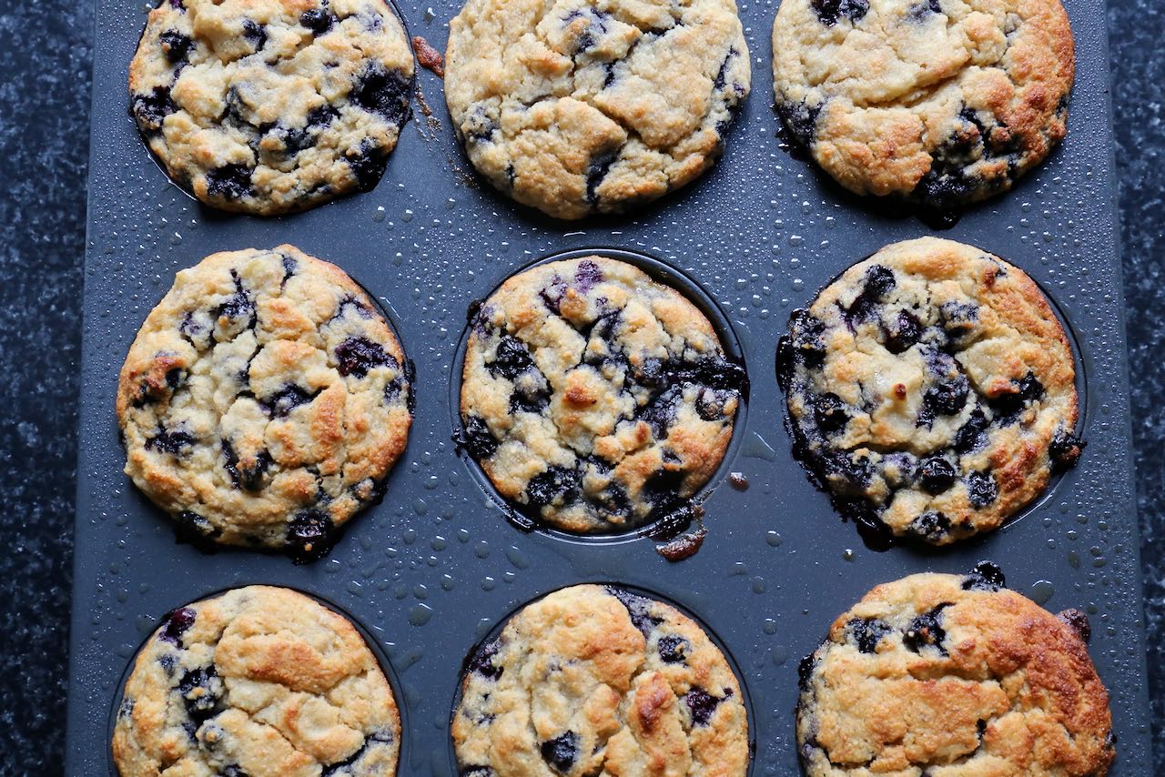 Bake Gluten Free Blueberry Banana Muffins until browned and crunchy.
