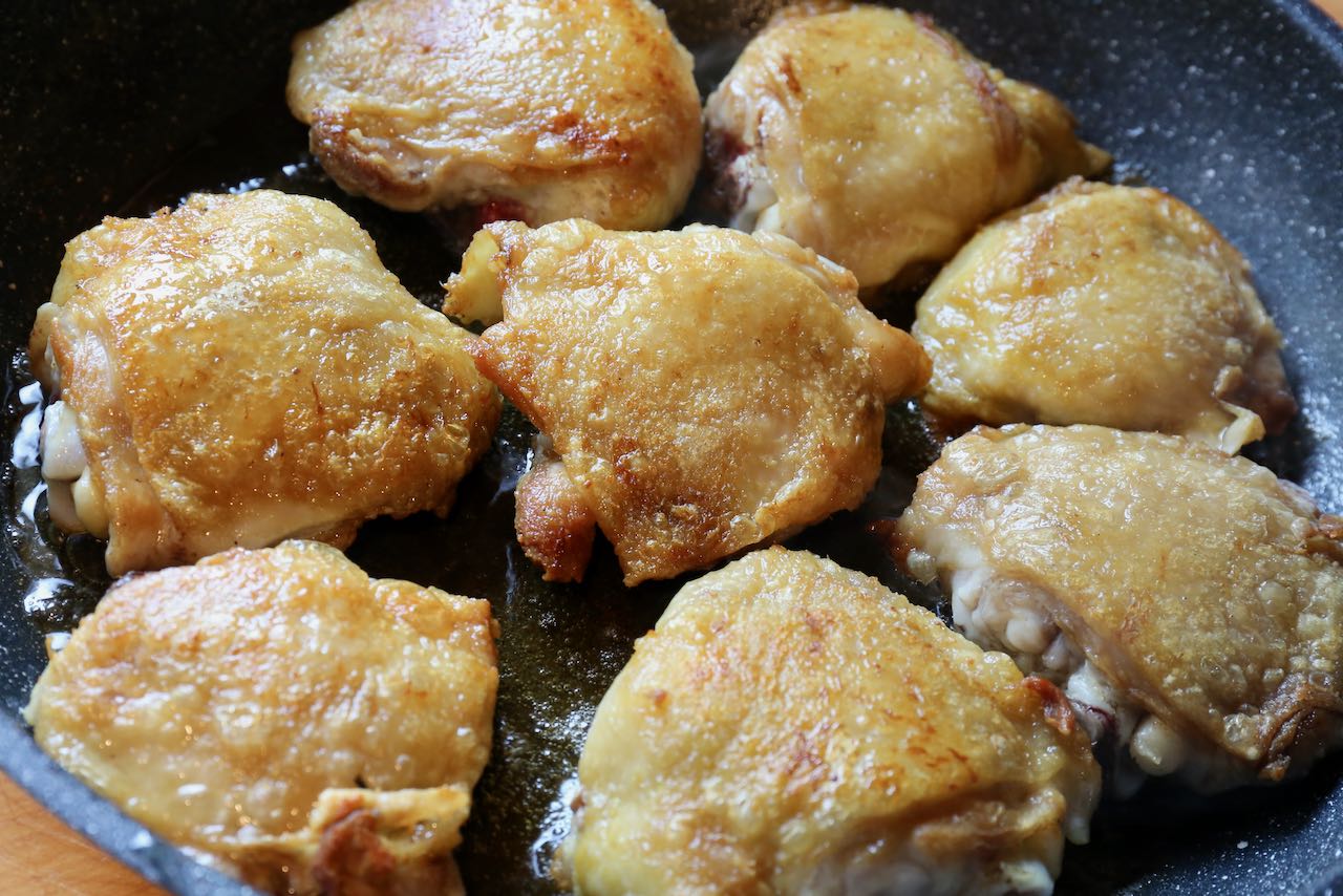 Cook chicken thighs in a large skillet until the skin is browned and crispy.