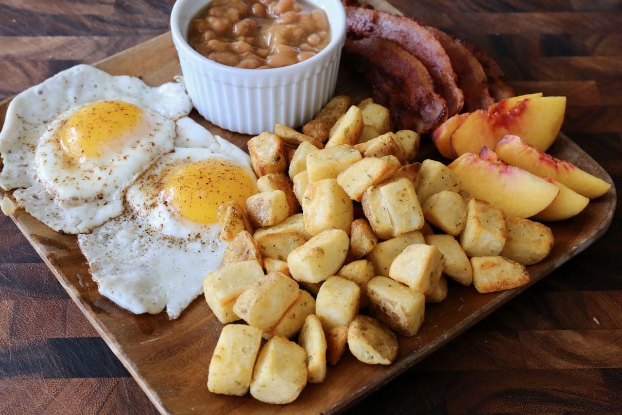 Serve Air Fryer Home Fries with eggs, baked beans, bacon and fresh fruit.
