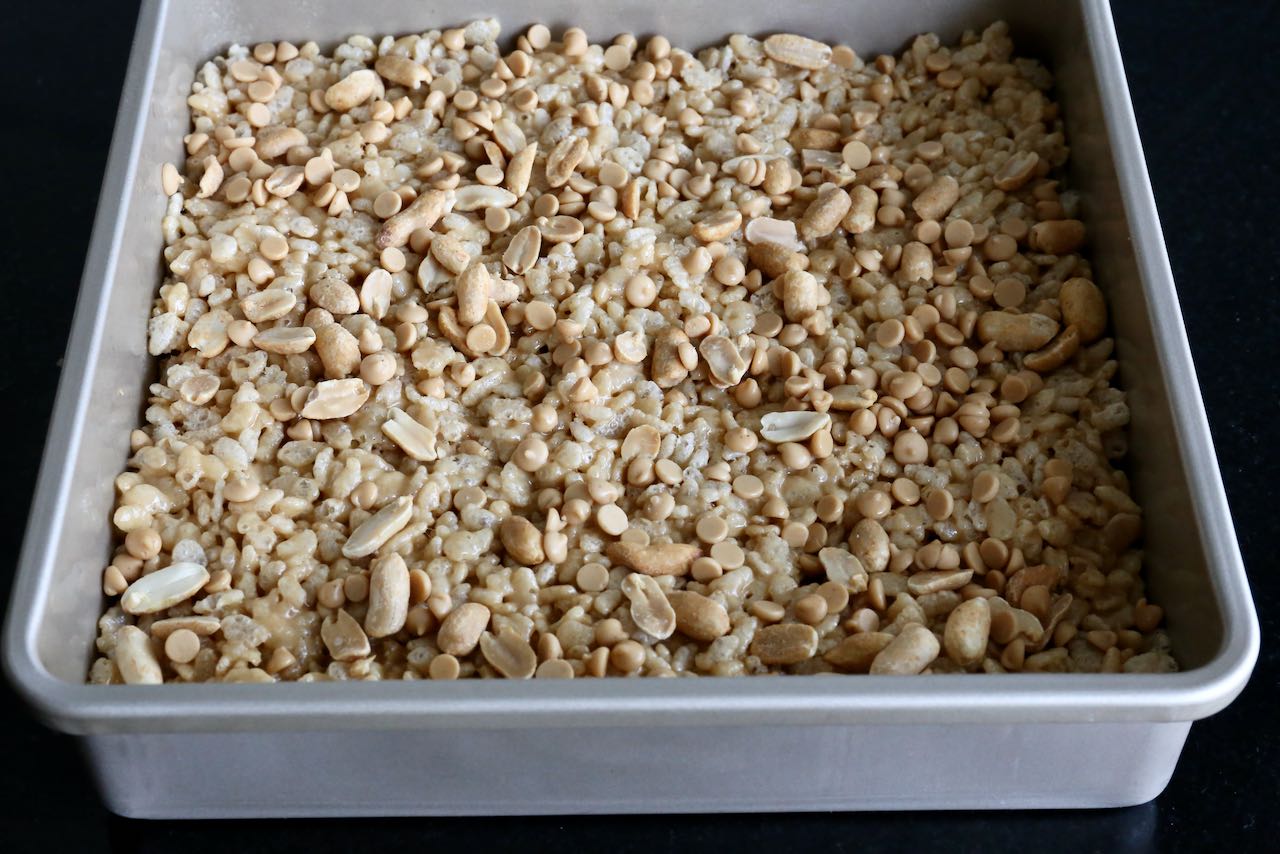 Prepare Peanut Butter Rice Krispies in a square metal baking tin.