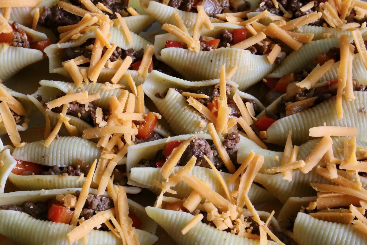 Sprinkle Philly Cheesesteak Stuffed Pasta Shells with shredded cheddar cheese before baking.