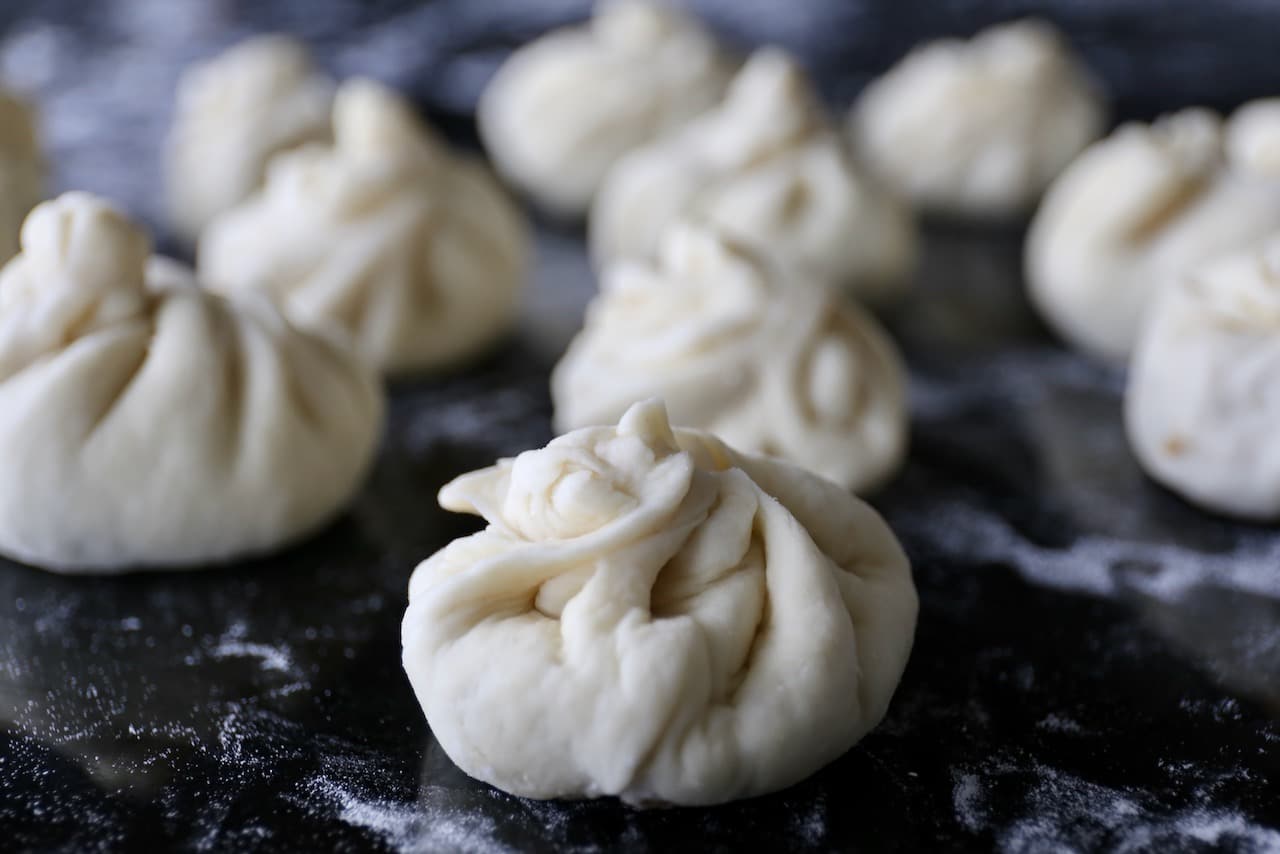 Wrap Chinese Fried Buns to ensure the filling is sealed inside before cooking.