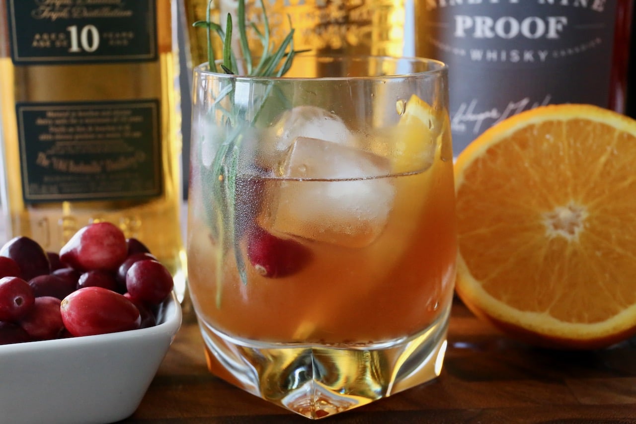 Muddle the Christmas Old Fashioned with fresh cranberries and an orange slice before pouring into a rocks glass.