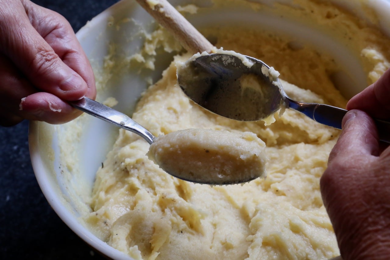 Use 2 small spoons to form Potato Fritter dough into quenelles.