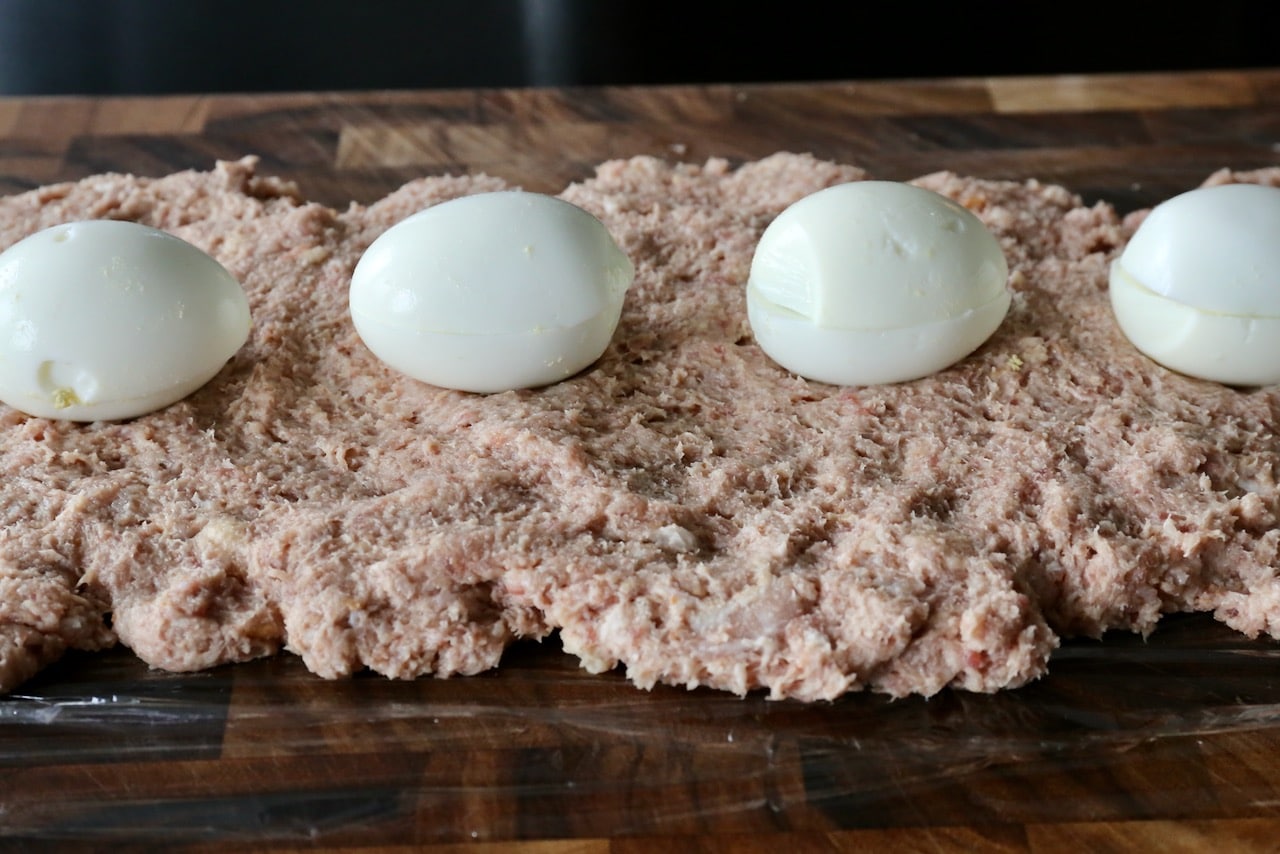 Line the centre of the minced beef and pork mixture with hard boiled eggs.