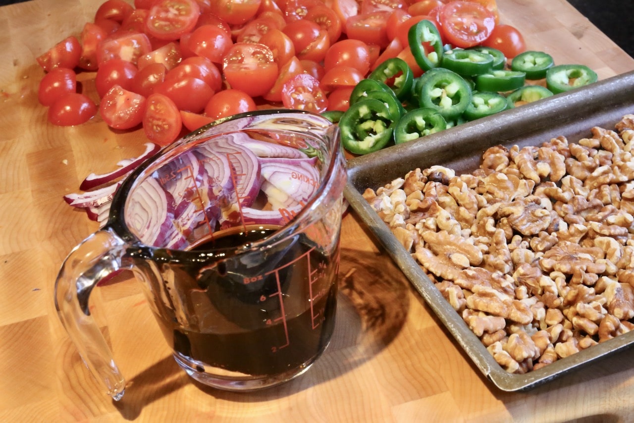 Gavurdagi Salatasi is a Turkish salad featuring tomatoes, peppers, onion, walnuts and pomegranate molasses dressing.