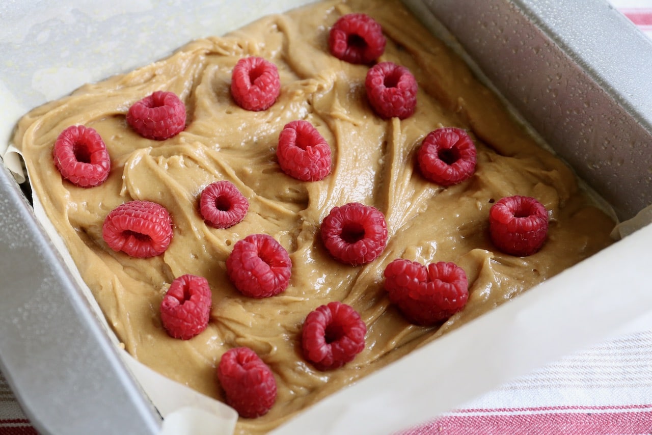 This blondies recipe is baked in a square tin and stuffed with fresh raspberries.