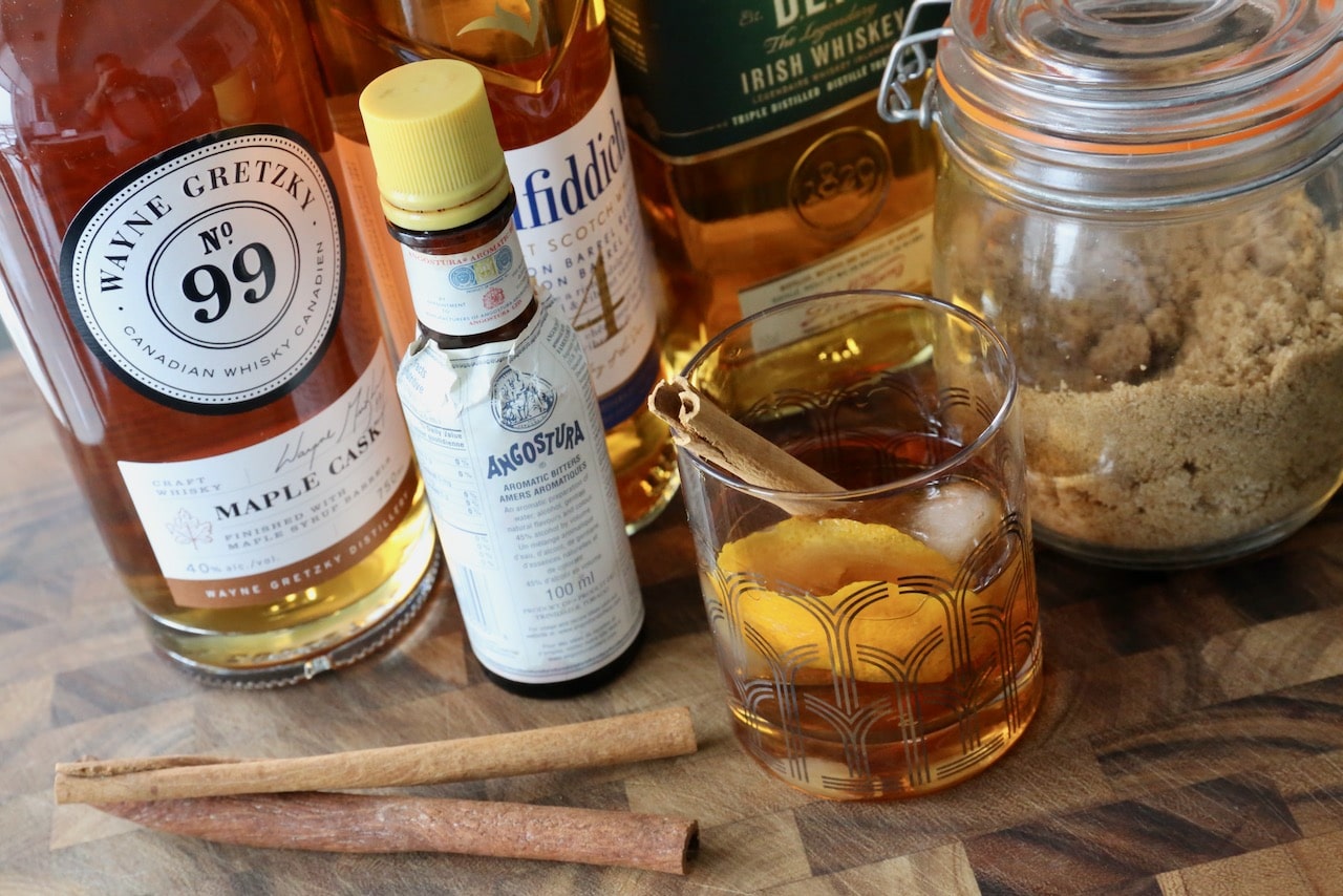 Garnish the cocktail glass with a cinnamon stick and orange peel.