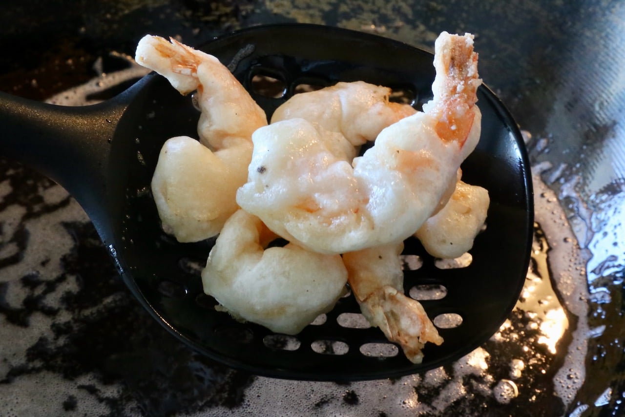 Remove fried battered shrimp once the exterior is lightly browned and crispy.