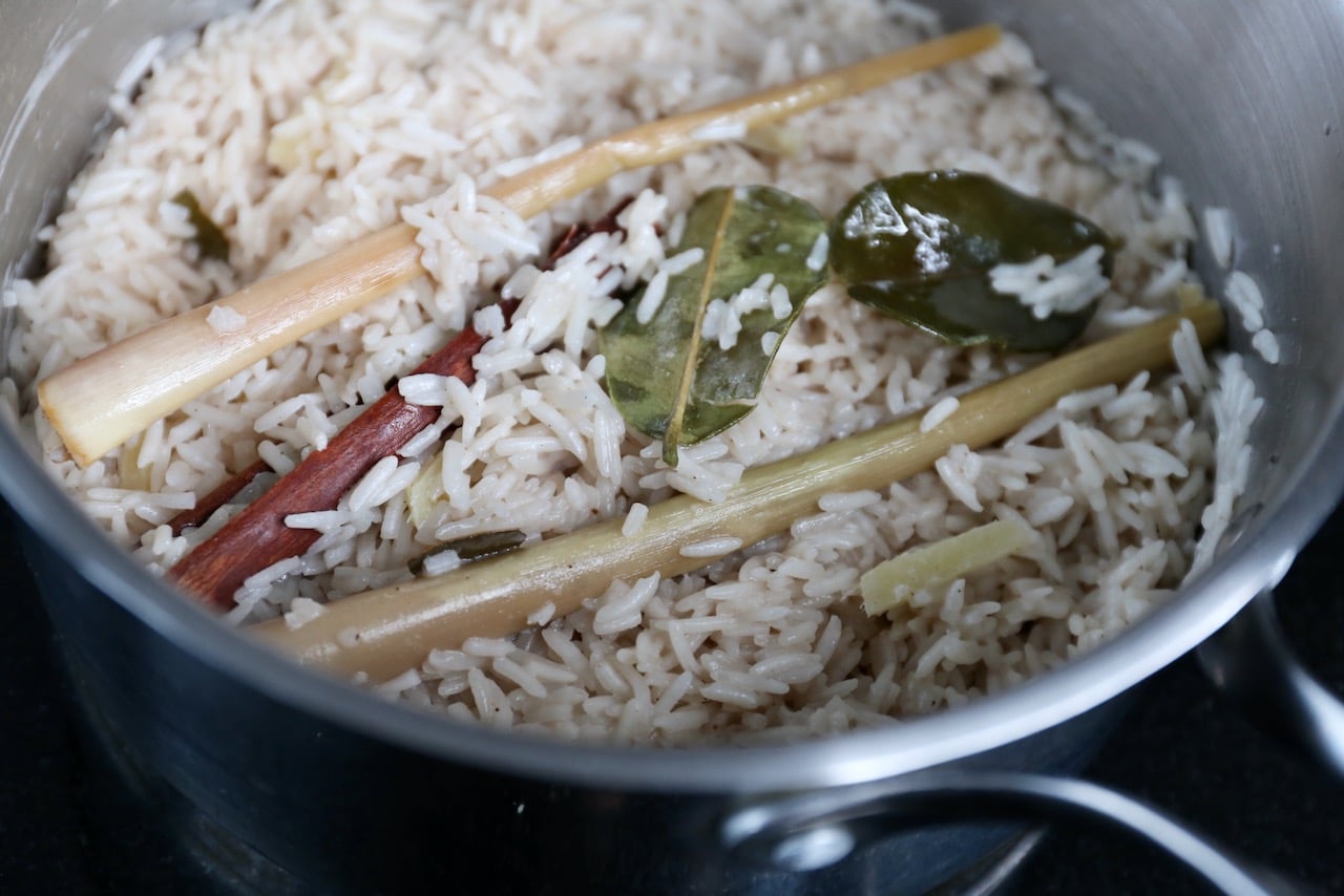 Cook Nasi Uduk in a pot with whole lemongrass, lime leaf and cinnamon to flavour the rice. 