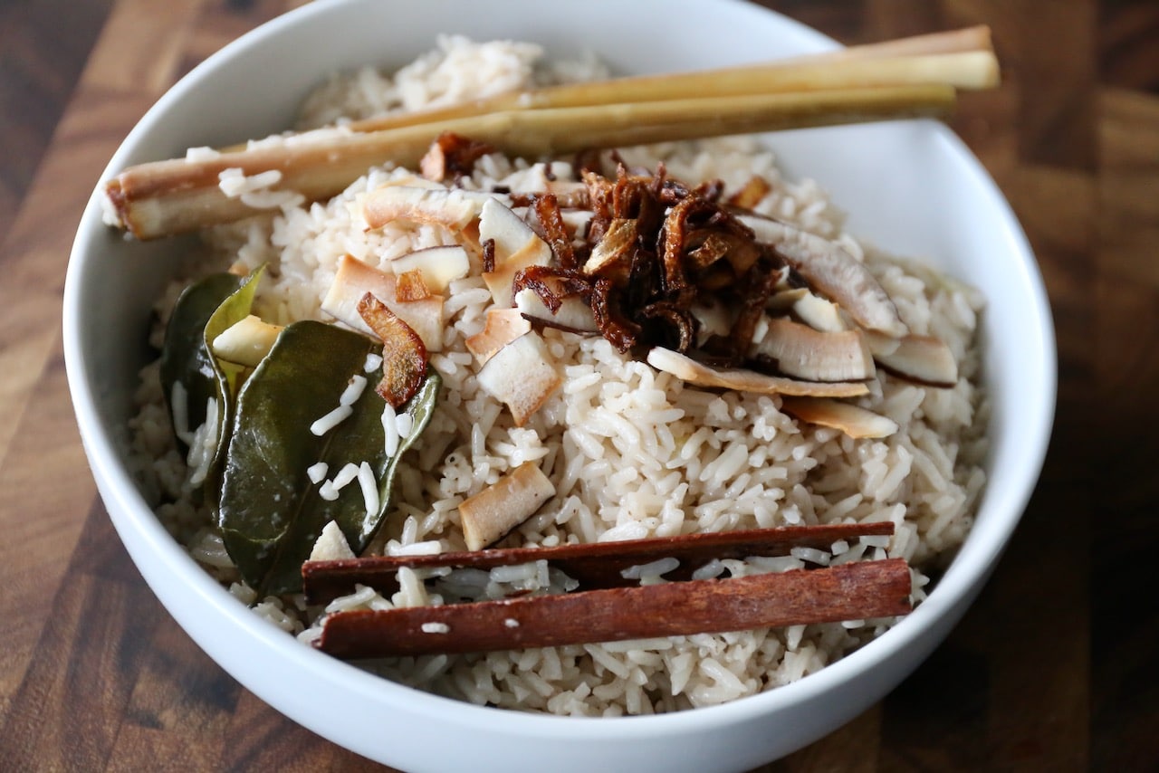 Garnish Indonesian Coconut Rice with fried shallots and coconut chips.