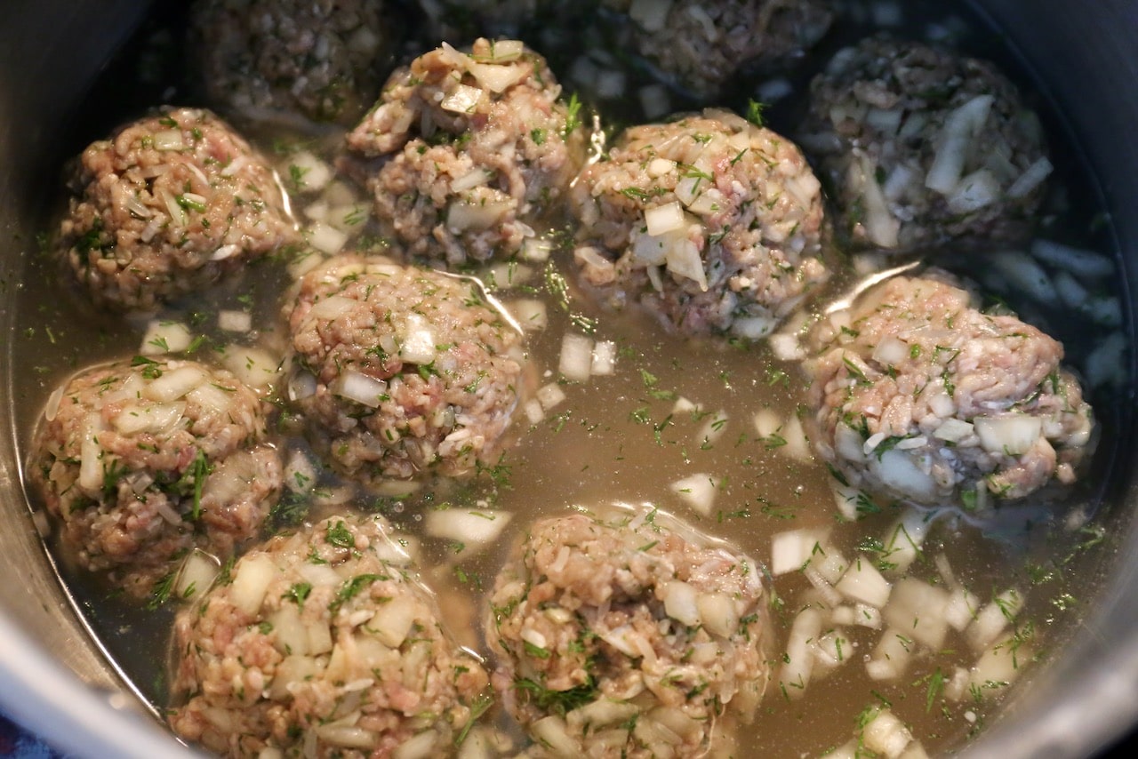 Giouvarlakia meatballs floating in soup broth.