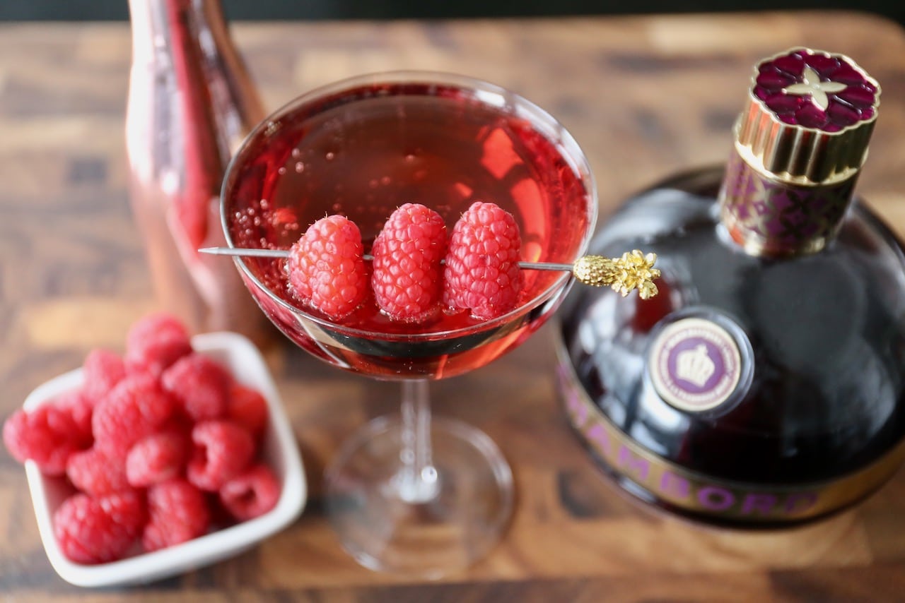 Garnish a homemade Chambord Royale with a cocktail pick skewered with fresh raspberries.