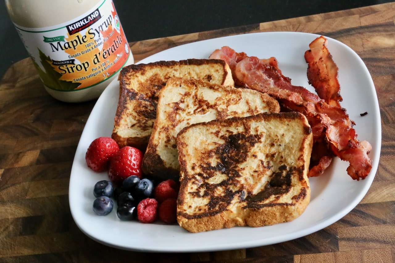 Serve Buttermilk French Toast with maple syrup, crispy bacon and fresh berries.