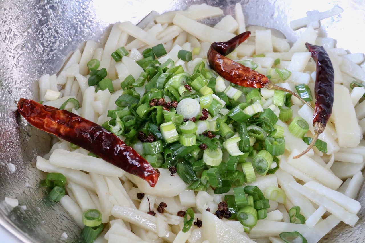 Toss cooled shredded potato with scallions, oil, vinegar, dried red chili and Sichuan peppercorns.