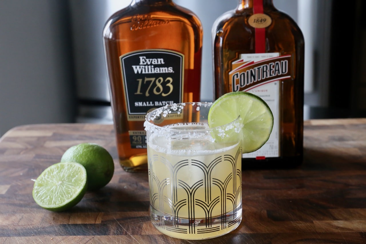 Garnish a Bourbon Margarita with a salt rim and slice of lime.