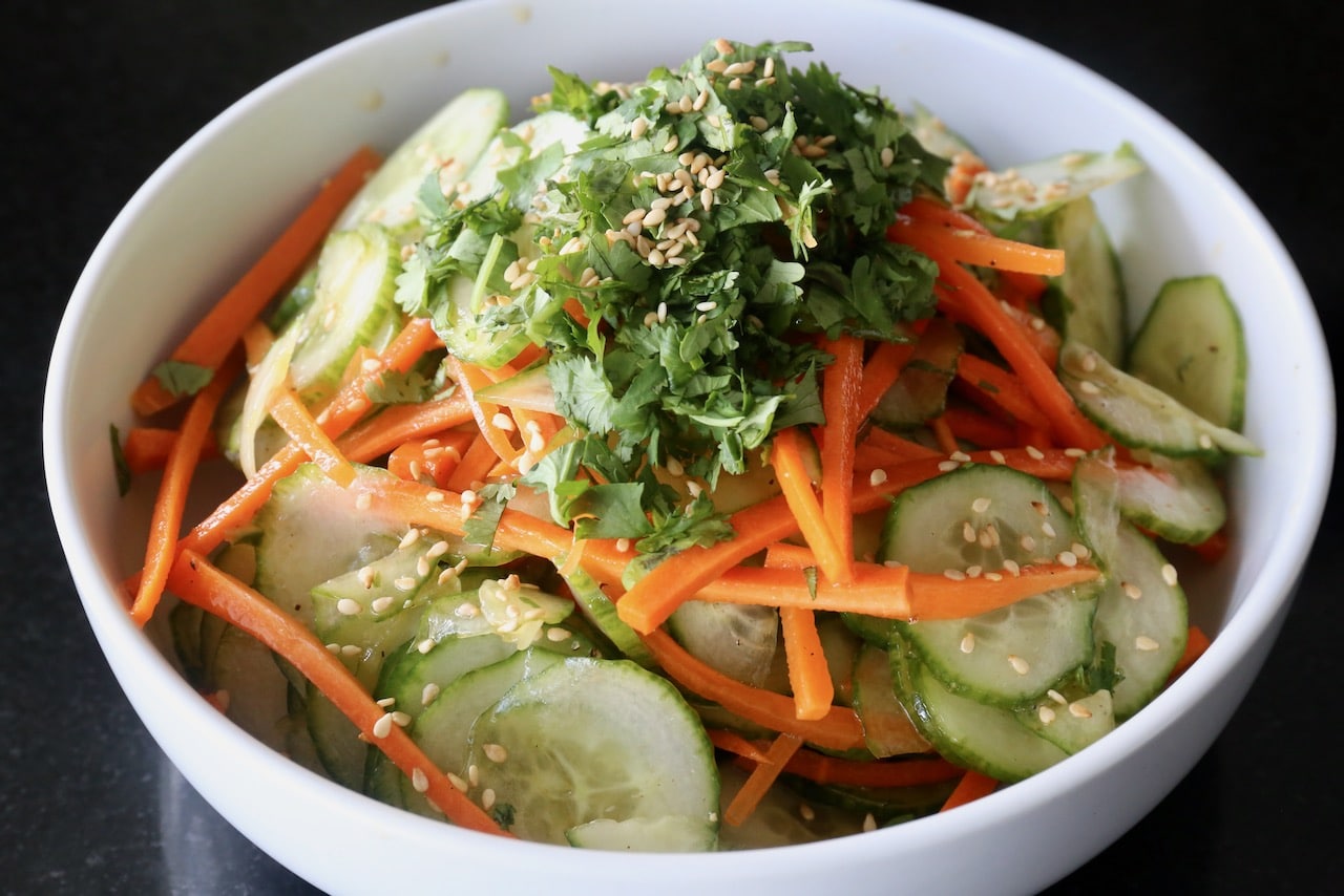 Garnish the salad with chopped cilantro and sesame seeds.