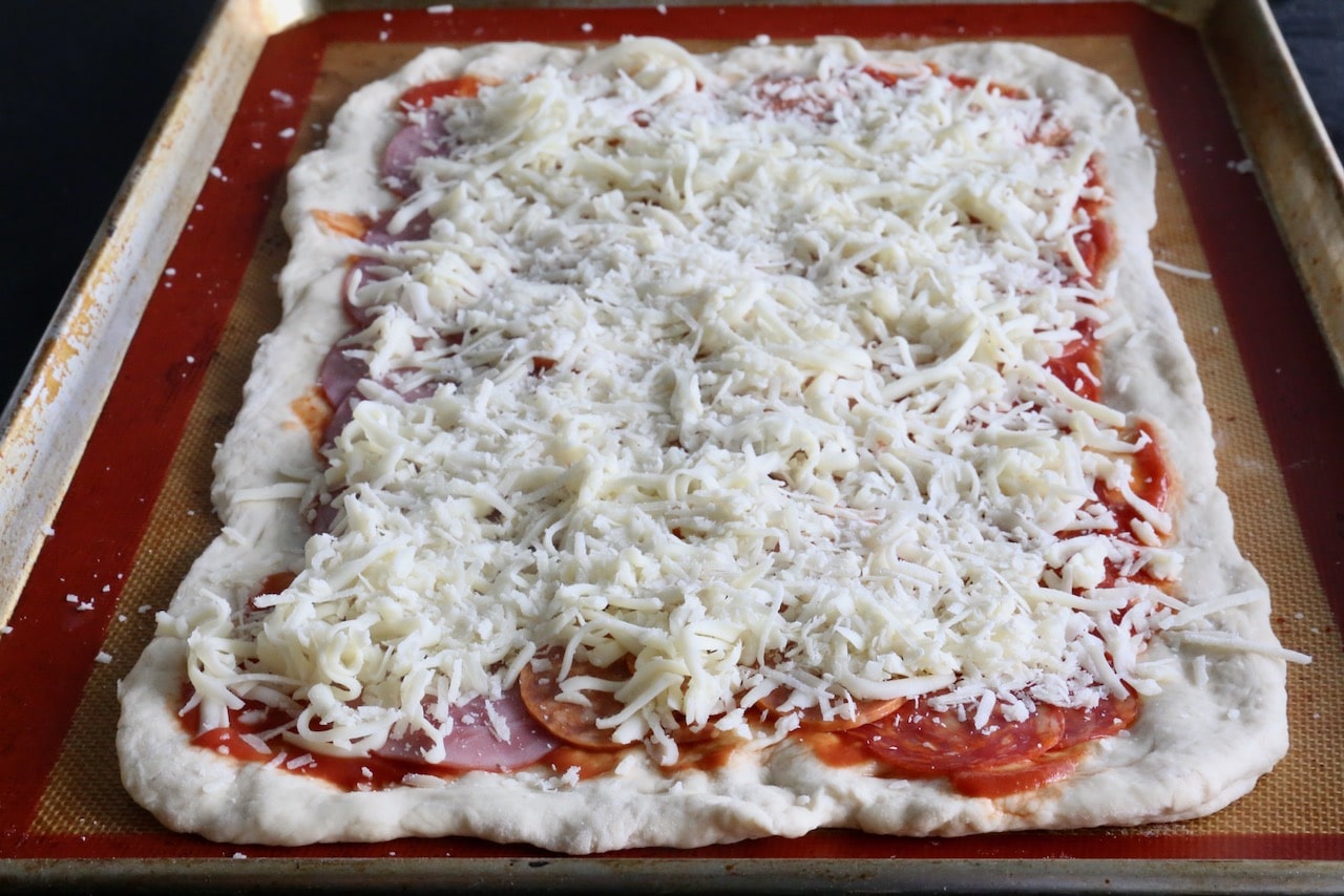 Top the meats with shredded mozzarella cheese.