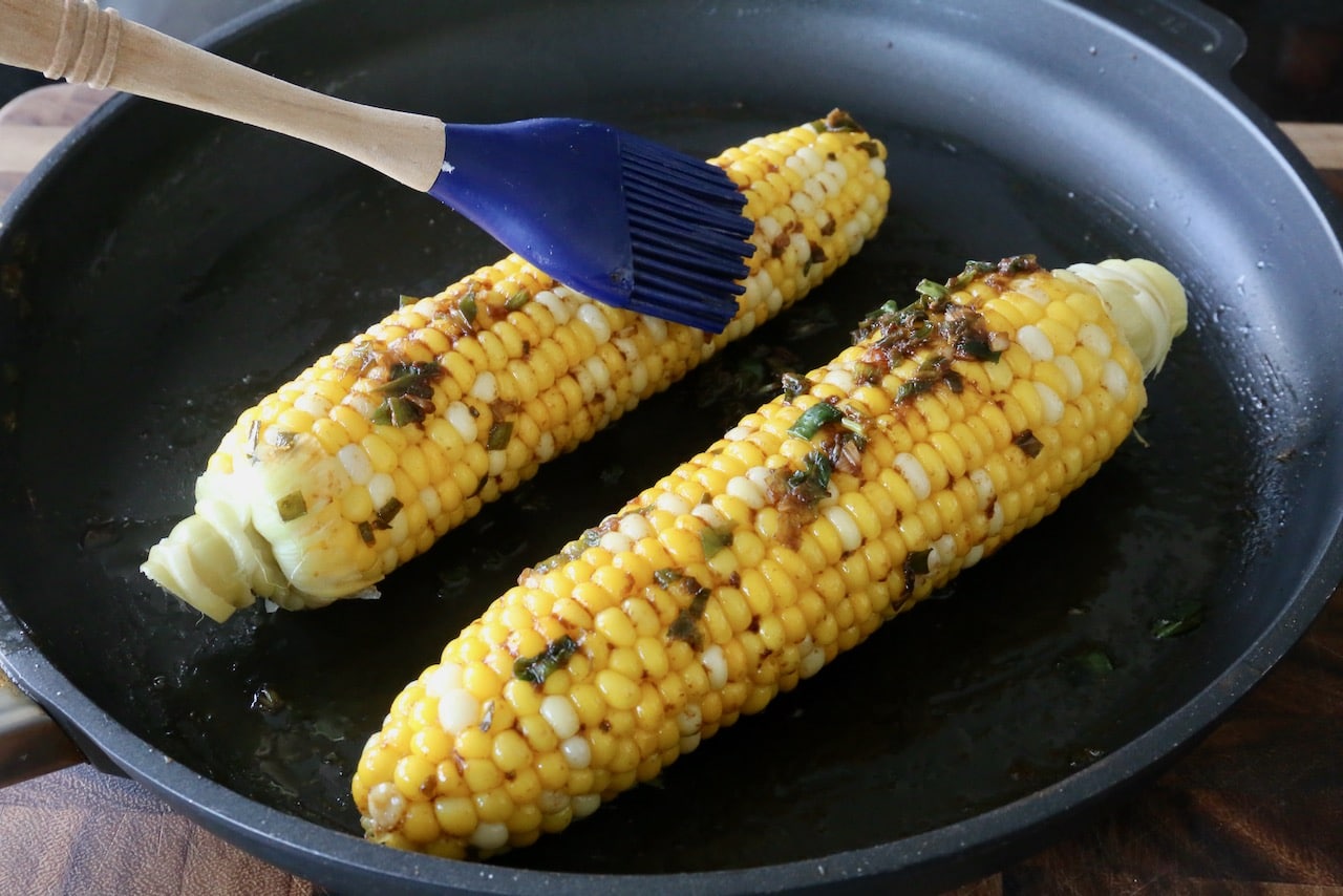 Slather corn on the cob with Bap Nuong sauce using a pastry brush.