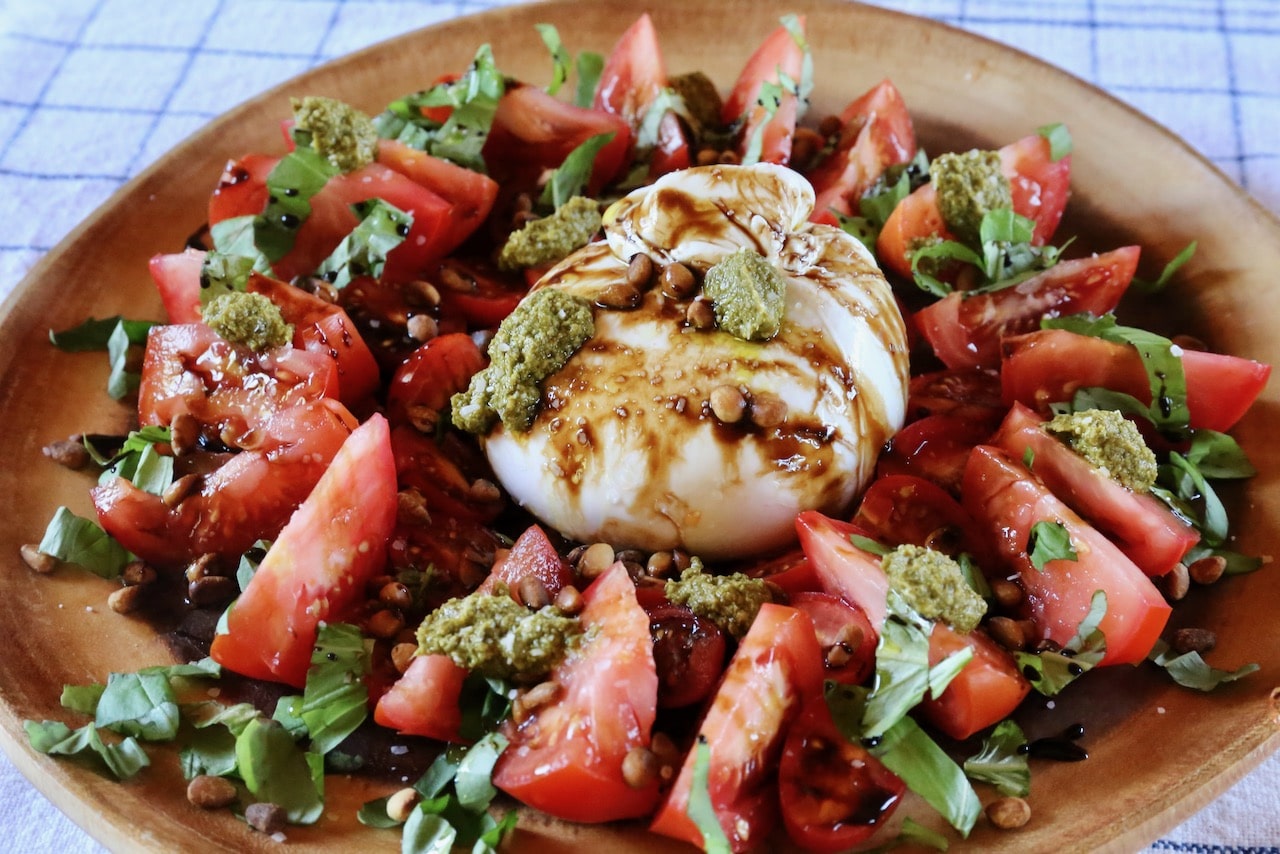 Burrata Caprese is an Italian salad featuring sliced tomatoes, basil and creamy fresh cheese.