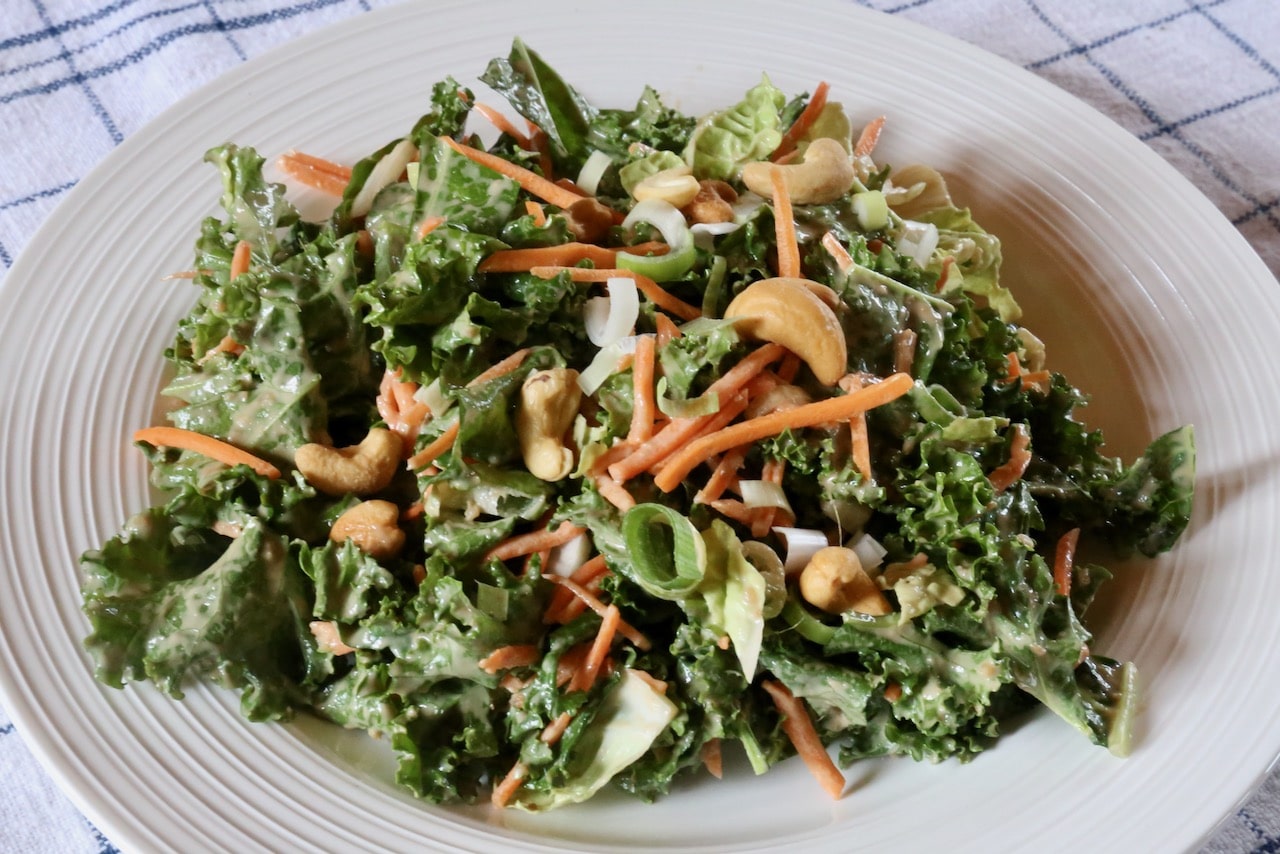 Garnish the salad with roasted cashews and sliced scallions.