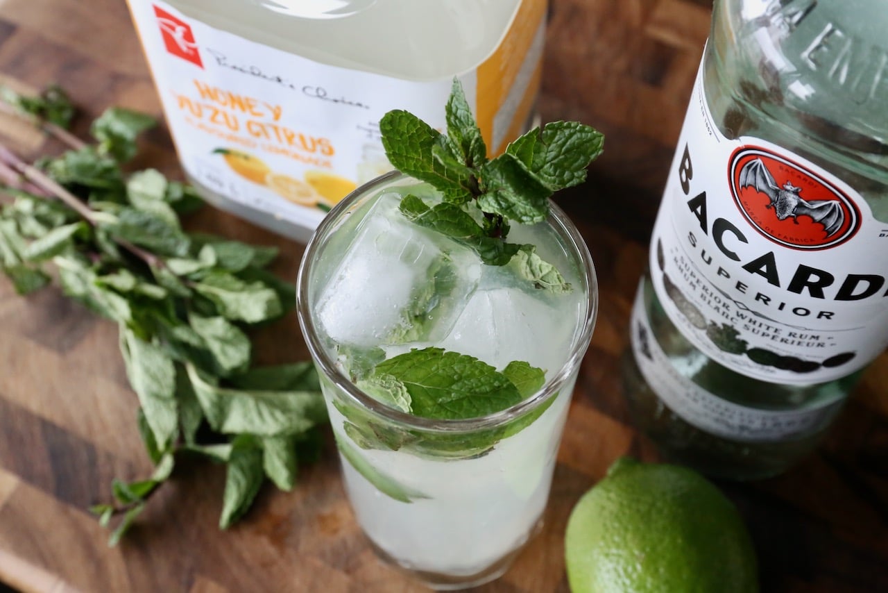 Garnish a Yuzu Mojito cocktail with a fresh mint sprig.