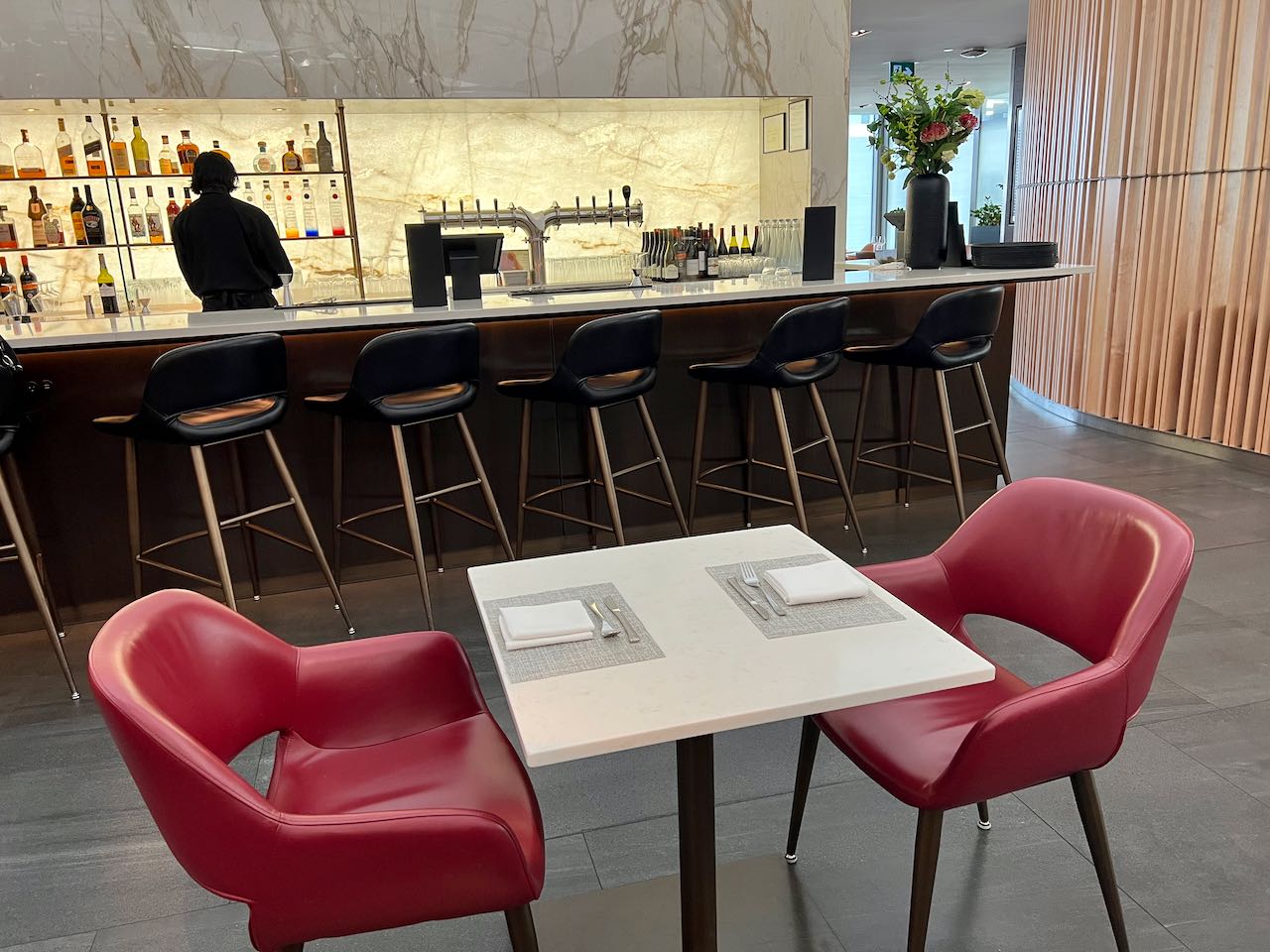 The luxurious airport lounge has a white marble clad cocktail bar.