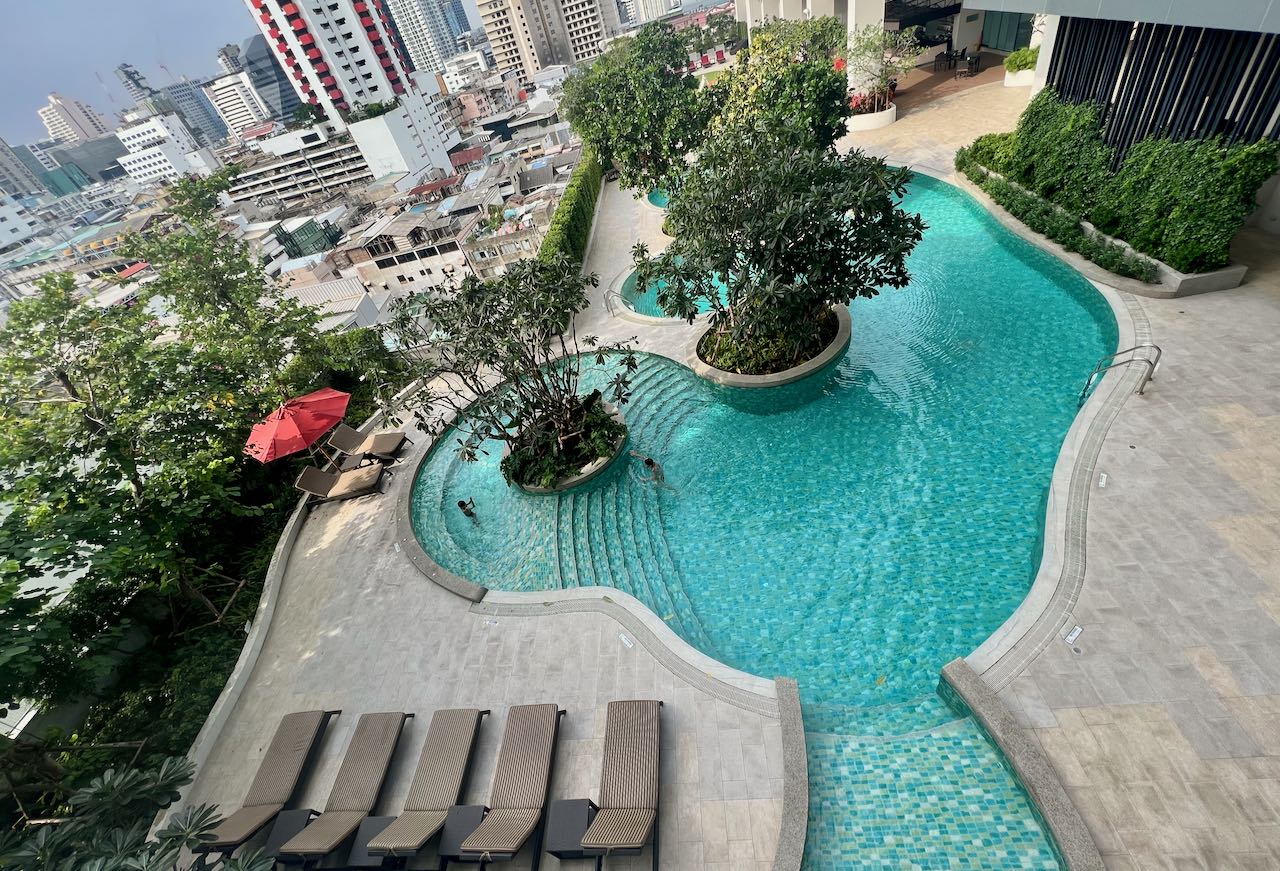 Amari Bangkok has a freeform salt water pool surrounded in lush greenery.