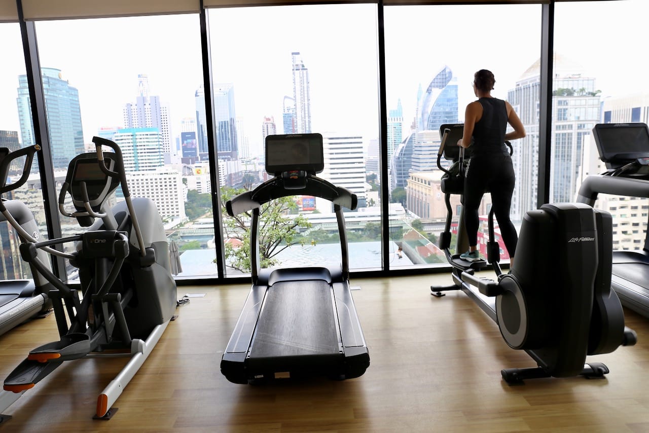 The gym at Sindhorn Midtown Bangkok sits perched over the rooftop pool offering scenic views of the skyline. 